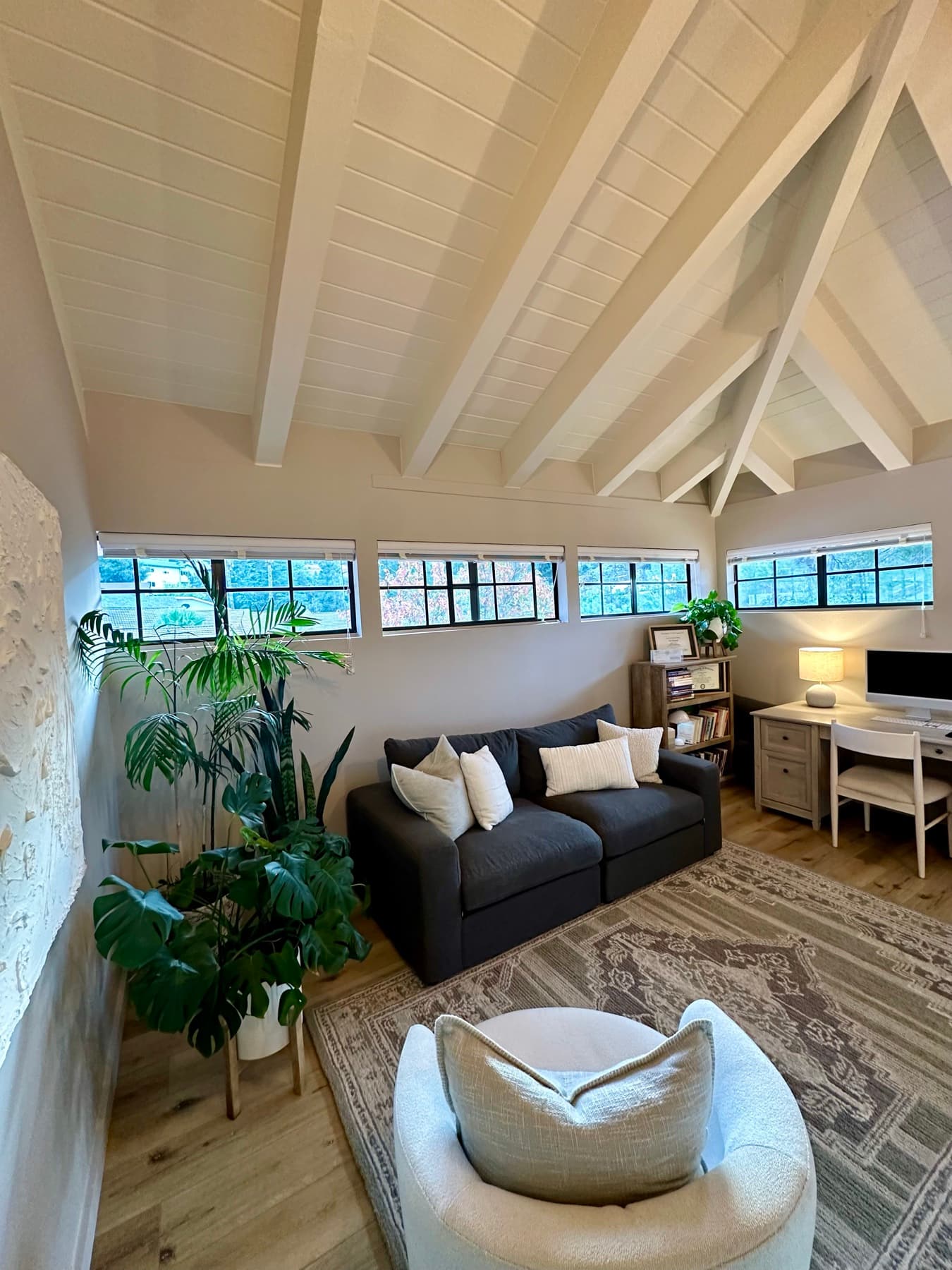 The office, looking up toward the vaulted wood-beam ceiling and back windows
